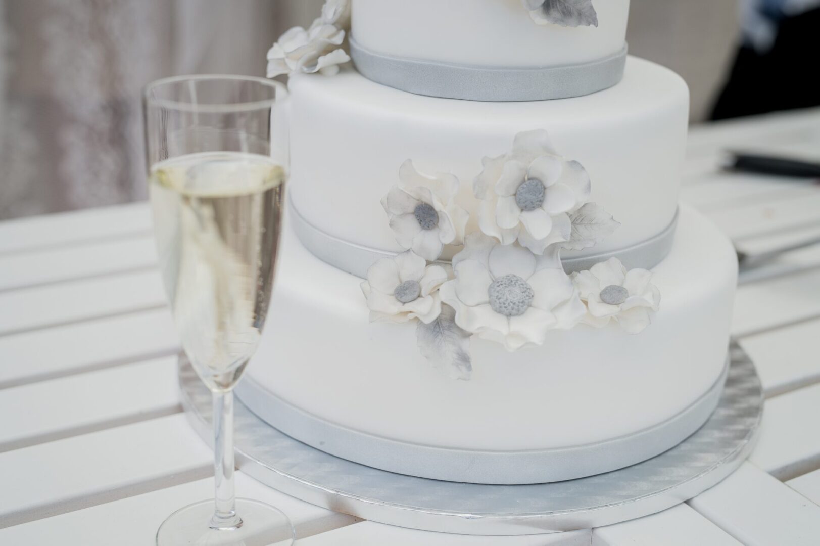 a white wedding cake and a glass of Champagne