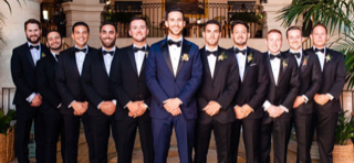 a groom in blue suit and groomsmen in black