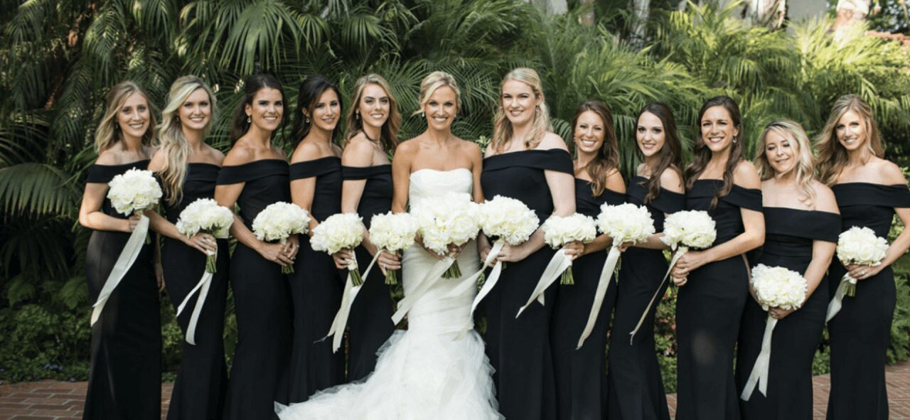a bride with her bridesmaid in black dresses